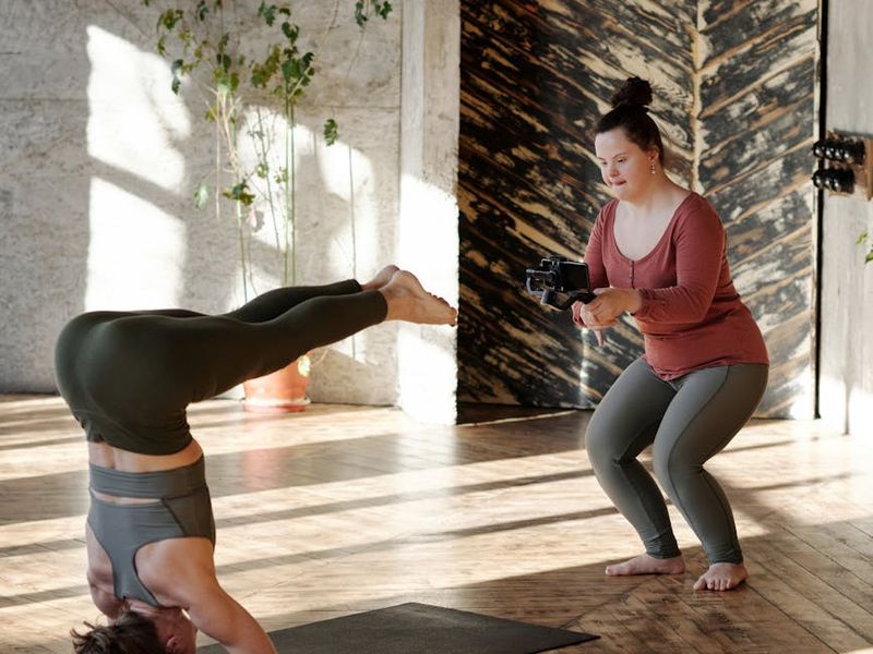 Person practicing yoga in a serene studio setting with morning light